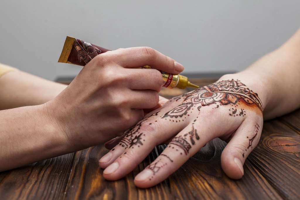 ঈদে মেহেদির ট্রেন্ড: নকশা ও রঙে নতুনত্ব 8 artist making mehndi womans hand