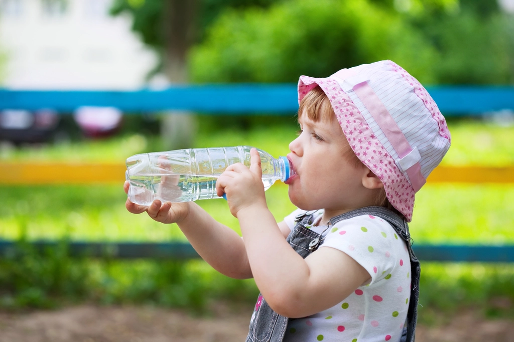গরমে শিশুদের সুরক্ষায় করণীয় 6 child drinks from plastic bottle